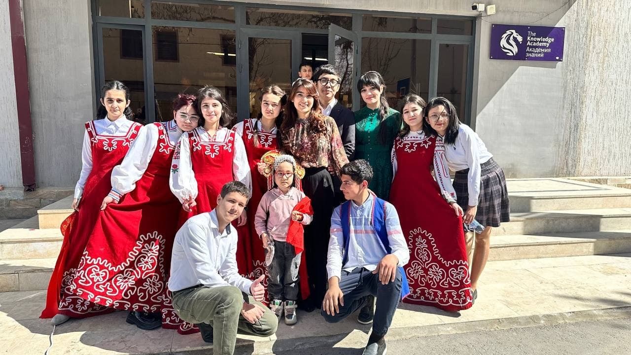 Milliy liboslardagi o'quvchilar maktab kirish eshigi oldida